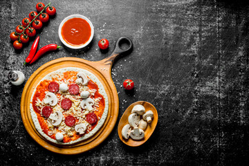Preparation pizza. Rolled out dough with tomato paste, sausages, mushrooms and cheese.