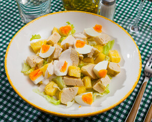 Closeup of salad with chicken, sweet pineapple and egg at plate
