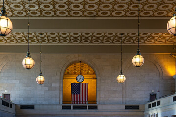 Interior of train station in New Haven with brick wall, decorative ceiling, and lamps