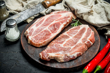 Raw pork steaks with aromatic and herbs and spices.
