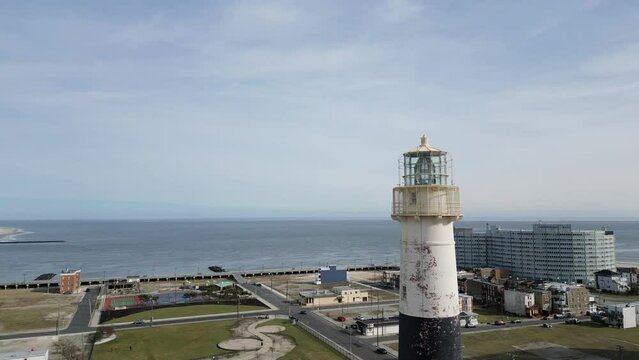 An arc shot circling the top of an old lighthouse with Atlantic City and Brigantine in the background