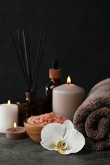 Obraz na płótnie Canvas Beautiful composition with burning candles and different spa products on dark grey table