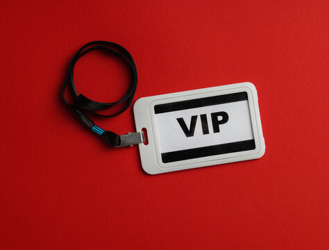 Plastic vip badge on red background, top view