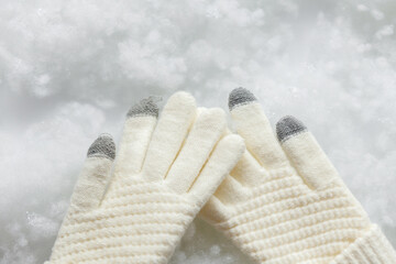 White gloves. Gloves on a white background. Snowy background. Close up. COPY SPACE.