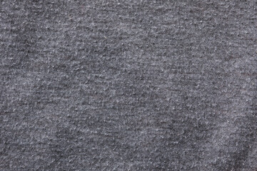Grey cloth with lint as background, closeup. Before using of fabric shaver