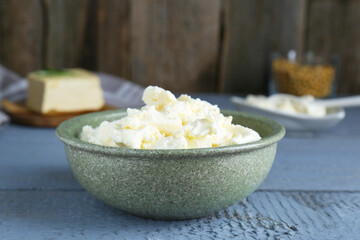 Delicious tofu cream cheese in bowl on grey wooden table