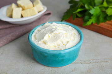Delicious tofu cream cheese in bowl on light table, closeup
