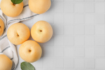 Delicious apple pears on white tiled table, flat lay. Space for text