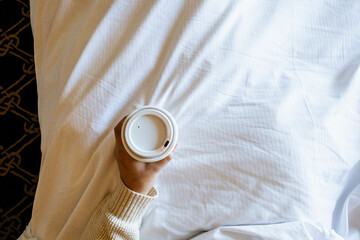 Woman Holding Paper Cup of Coffee in Bed with Lipstick
