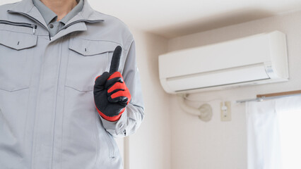 エアコンの掃除・点検をする作業服の男性