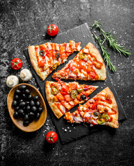 Slices of Mexican pizza with tomatoes, olives and rosemary.