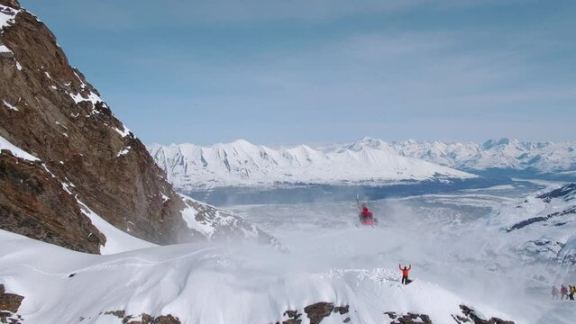 Heli-Skiing helicopter landing on a snowy mountain in Alaska