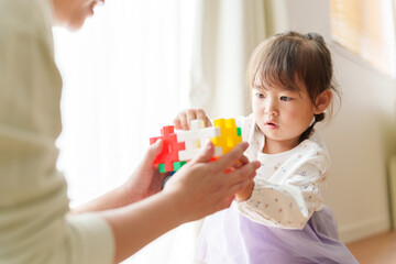 Obraz na płótnie Canvas おもちゃで遊ぶ女の子とお母さん