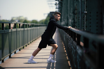Obraz premium sportive runner stretch tendons and ligaments in legs to warm up the body for perfect recreation to prevent injury