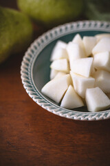 Close Up of Bowl of Chopped Bartlett Pears on Wooden Table