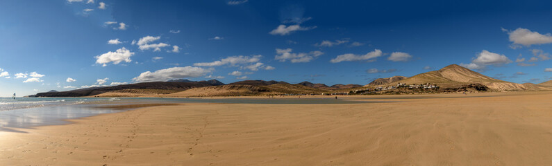 Fototapeta na wymiar spiaggia infinita 01 - panoramica con oceano, spiaggia dorata e montagne vulcaniche nere