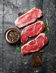 Raw marbled beef steaks with salt and spices.