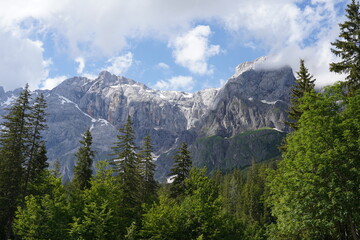 landscape with clouds in the mountains, blue sky, snowy peaks
