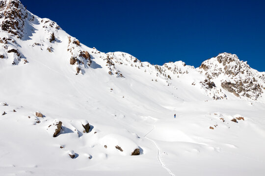 A male backcountry skier skins through fresh snow in the Beehive Basin near Big Sky, Montana.