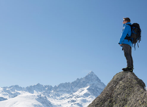 Portrait of mountaineer on summit, above mtns