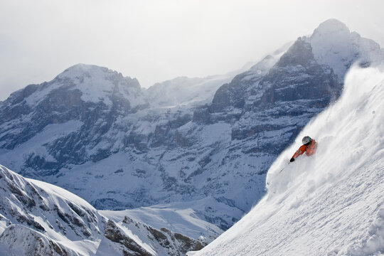 A man skis in fresh, deep, untracked powder at Grindelwald, Switzerland.