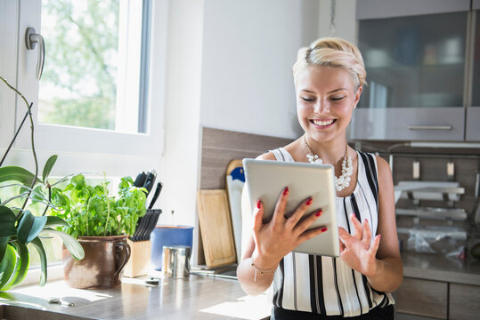 Young woman using digital tablet in the kitchen, Bavaria, Germany