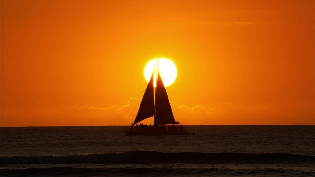日没イメージ　海に沈む夕日とヨットのシルエット