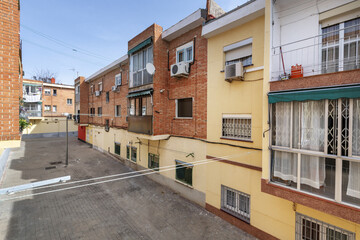 Facade of three-story residential buildings with a brick facade and ropes for hanging clothes