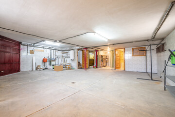 Ground floor of a detached house dedicated to a garage with a cement floor