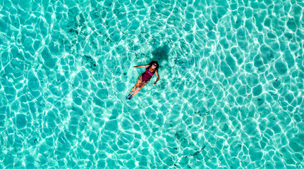 Drone Aerial of Pretty Girl Floating in Crystal Clear Blue Water at Beach In Tropical Paradise, Palawan, Philippines 1