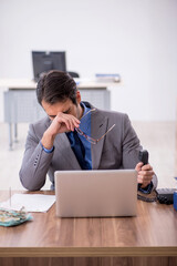 Young male employee talking by phone