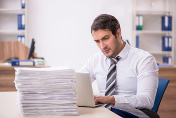 Young male employee unhappy with excessive work in the office