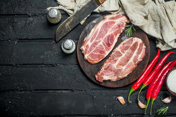 Raw pork steaks with aromatic and herbs and spices.