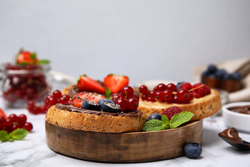 Tasty organic rusks with different toppings and ingredients on white marble table, closeup