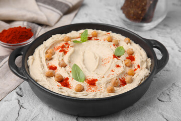 Delicious hummus with chickpeas and paprika served on white textured table, closeup