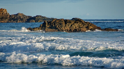 Waves breaking around a rock just off the beach in Zipolite, Mexico