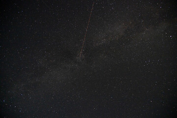 Satellite trail passing through the milky way, night-sky