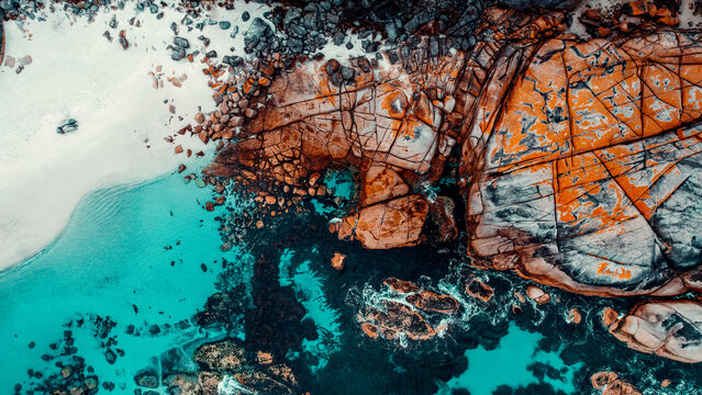 Drone Aerial of White Sand Beach and Orange Lichen Covered Boulders at Bay of Fires, Tasmania, Green Blue Water