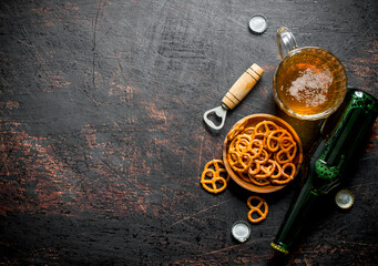 Glass of beer and snacks pretzels in the bowl.
