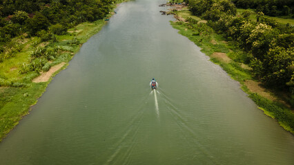 aerial view of a boat traveling on the Opak river in Bantul area, Indonesia. Sunny day