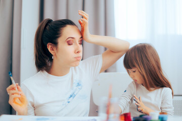 Mom and Daughter getting Paint All Over their Clothes. Stressed mother feeling concerned about...