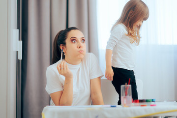 Stressed Tired Mother Playing with her Active Child. Kid having a lot of energy and little...