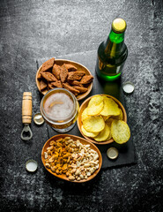 Beer and various kinds of snacks in the bowls.