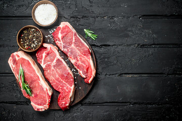 Raw beef steaks with spices.