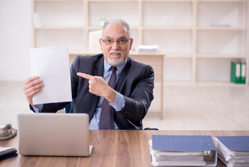 Old male employee working in the office