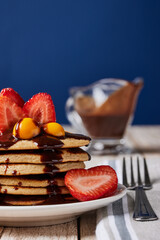Delisiosos panquetes calientes y frutas para el desayuno con la familia en fondo azul/ hot pancake breakfast