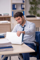 Fototapeta premium Young male employee working in the office