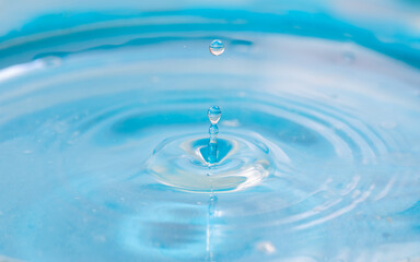 Naklejka na ściany i meble light blue water drop splash on surface background.