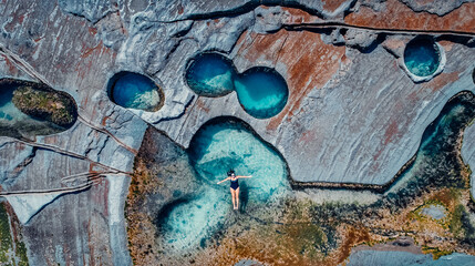 Overhead Aerial of Girl Floating in Famous Figure 8 Pools In Royal National Park, Australia
