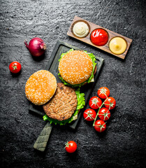 Burgers with tomatoes,sauces and onions.